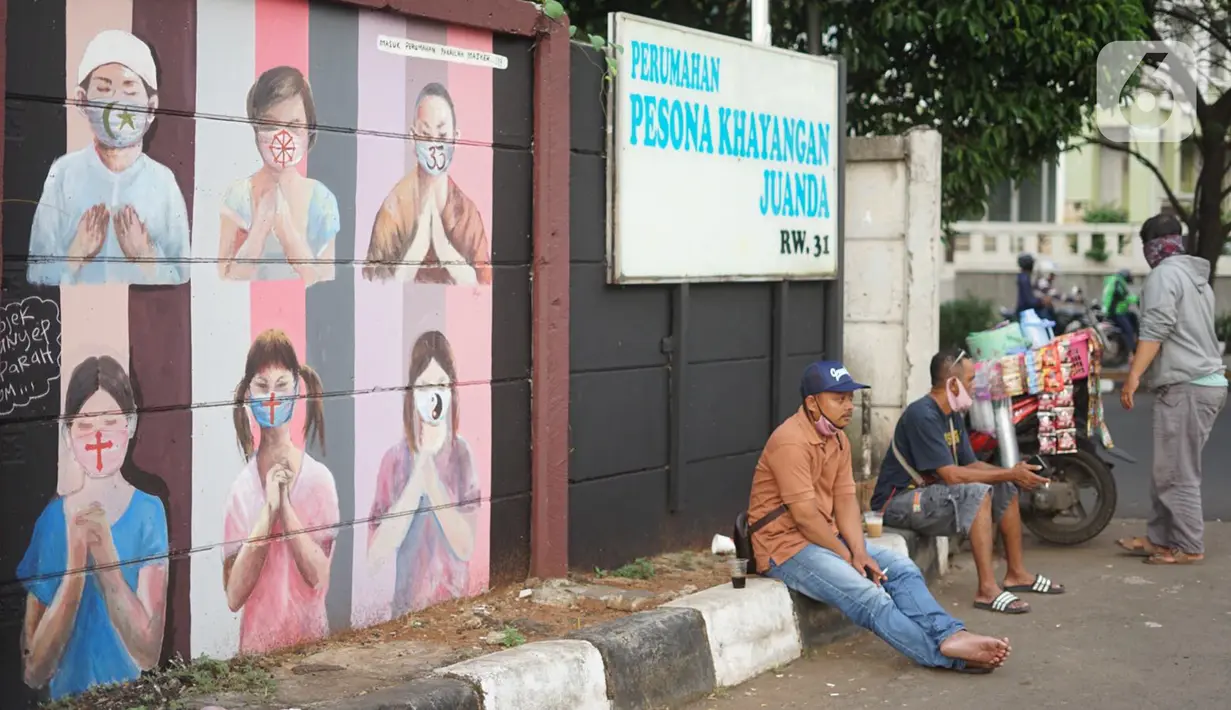 Warga duduk di dekat mural bergambar simbol orang berdoa menggunakan masker di kawasan Juanda, Kota Depok, Jumat (26/6/2020). Mural yang dibuat warga itu bertujuan memberi edukasi untuk menggunakan masker sebagai salah satu pencegahan dan penyebaran COVID-19. (Liputan6.com/Immanuel Antonius)