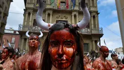 Sejumlah aktivis membasahi wajahnya dengan darah palsu saat aksi menolak festival San Fermin di Pamplona, Spanyol, (5/7). Festival yang menampilkan tradisi lari bersama banteng dan matador ini merupakan aksi yang mengorbankan hewan. (REUTERS/Susana Vera)