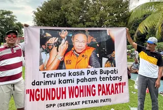 Aktivis Serikat Petani Pati bentangkan spanduk saat syukuran di Alun-Alun Pati. (Liputan6.com/ Arief Pramono)