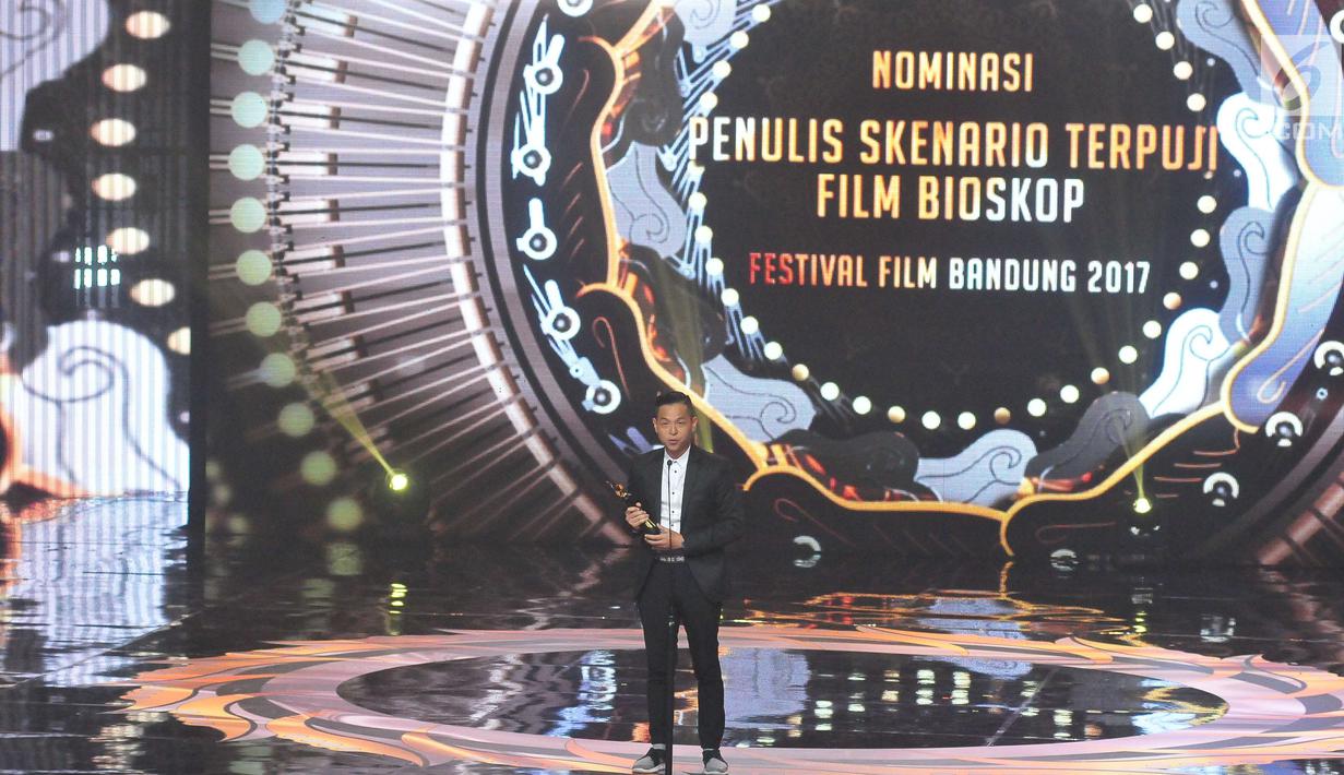 Aktor Ernest Prakasa menerima penghargaan Penulis Skenario Terpuji Film dalam ajang Festival Film Bandung 2017 di studio 6 Emtek, Jakarta (22/10). (Liputan6.com/Helmi Afandi)
