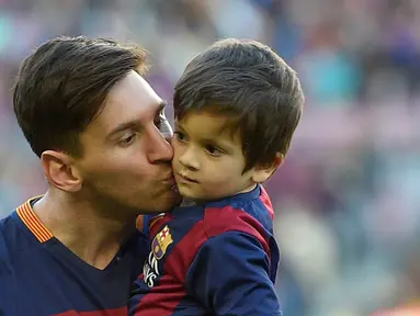 Pemain Barcelona, Lionel Messi, mencium putranya Thiago Messi jelang melawan Real Sociedad dalam lanjutan La Liga Spanyol di Stadion Camp Nou, Barcelona, (28/11/2015). (AFP Photo/Lluis Gene)