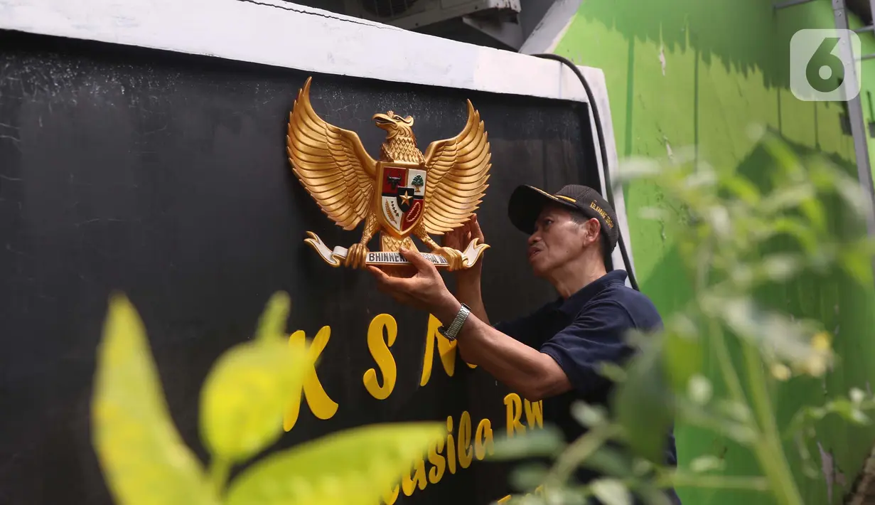 Warga memasang lambang burung Garuda Pancasila di sebuah tembok di di Kampung Pancasila, Karang Tengah, Kota Tangerang, Selasa (1/6/2021). Sejumlah kegiatan diadakan warga, Komunitas Taman Potret dan TNI ini untuk memperingati Hari kelahiran Pancasila. (Liputan6.com/Angga Yuniar)