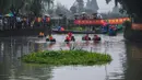 Warga desa berpartisipasi dalam kontes mendayung ember di Desa Quanxin, Kota Huzhou, Provinsi Zhejiang, China, Selasa (23/6/2020). Ember purun tikus (water chestnut) merupakan alat kerja tradisional yang dimiliki setiap rumah tangga di kota-kota perairan di China. (Xinhua/Xu Yu)