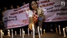 Massa dari Solidaritas Merah Putih menggelar aksi lilin dan tabur bunga di lokasi bom Terminal Kampung Melayu, Jakarta, Kamis (25/5). Aksi tersebut sebagai bentuk malam solidaritas duka untuk bom Kampung Melayu.(Liputan6.com/Faizal Fanani)
