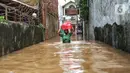 Warga berjalan menyusuri banjir yang merendam permukiman di kawasan Kebalen, Jakarta, Sabtu (20/2/2021). Curah hujan yang tinggi menyebabkan banjir setinggi orang dewasa di kawasan Kebalen. (Liputan6.com/Johan Tallo)