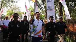 Ketua Koordinator Wilayah Grup Astra Bali Haris Prasetya membawa api obor Asian Games 2018 melewati Banjar Berseri Astra Denpasar (24/7). (Liputan6.com/Pool/Ilham)