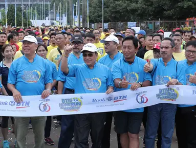 Direktur Utama Bank BTN Maryono (topi berkacamata hitam) melepas ribuan peserta home run in harmony di Senayan, Jakarta, Minggu (21/2). PT Bank Tabungan Negara (Persero) Tbk (BBTN) merayakan hari ulang tahunnya (HUT) ke 66. (Liputan6.com/Angga Yuniar)