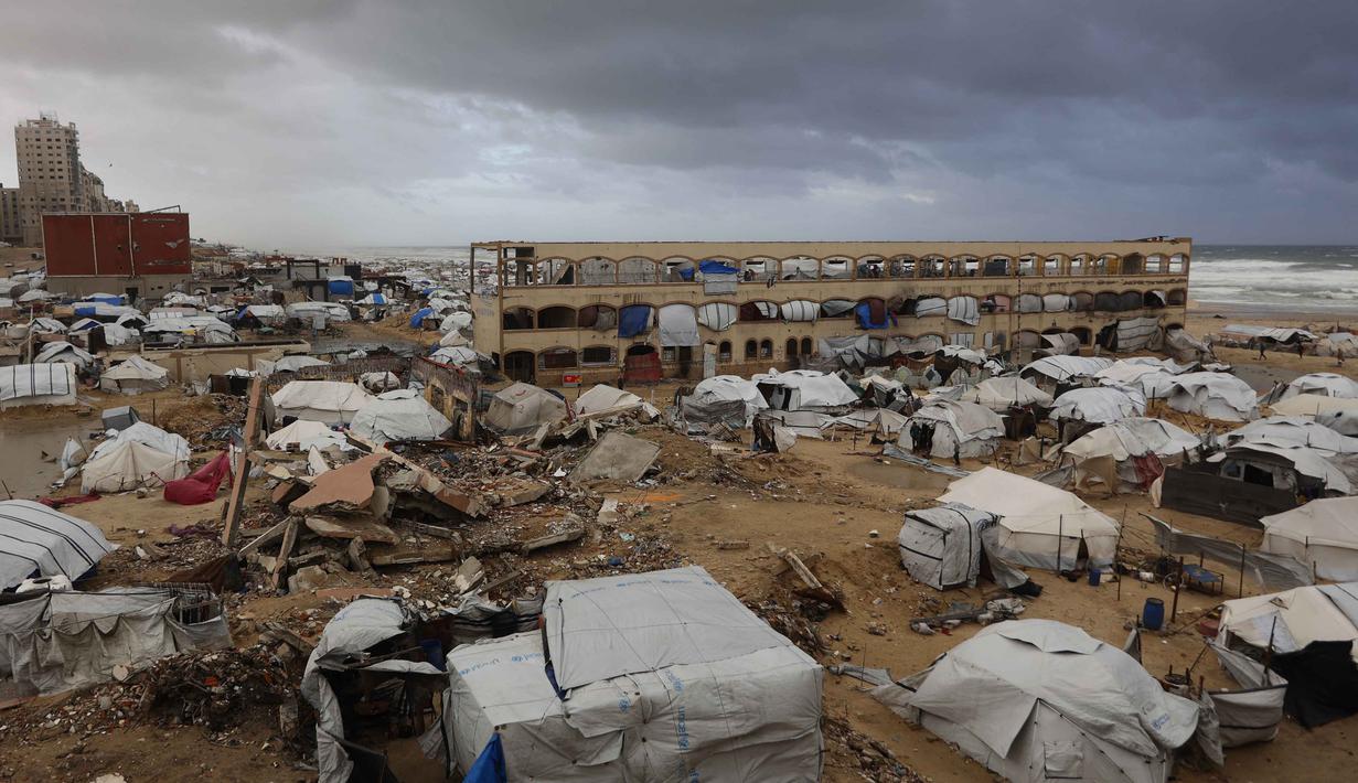 Sebuah foto menunjukkan tenda-tenda penampungan keluarga-keluarga Palestina yang mengungsi, didirikan di sepanjang pantai Kota Gaza saat angin musim dingin yang kencang menerpa wilayah tersebut pada Selasa 13 Januari 2026. Musim dingin menjadi ancaman nyata bagi para pengungsi Palestina di Jalur Gaza. (Omar AL-QATTAA/AFP)