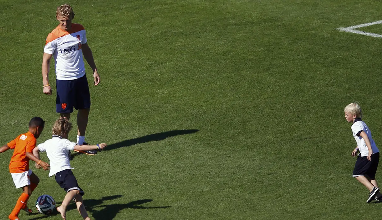 Pemain depan Timnas Belanda, Dirk Kuyt, bermain dengan sejumlah anak usai berlatih di Rio de Janeiro, (24/6/2014). (REUTERS/Ricardo Moraes)