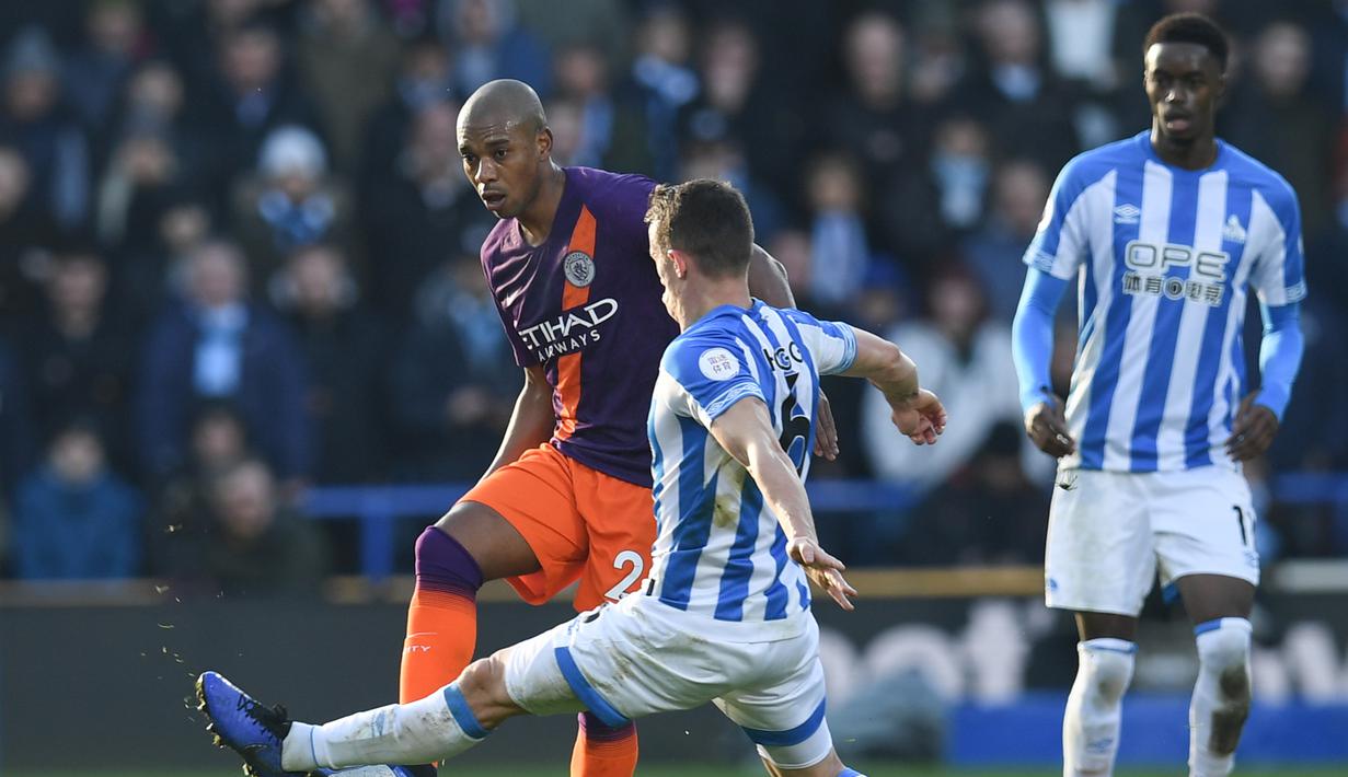 Gelandang Man City, Fernandinho saat dihadang pemain Huddersfield  pada laga lanjutan Premier League yang berlangsung di stadion John Smith, Huddersfield, Minggu (20/1). Manchester City menang 3-0 atas Huddersfield. (AFP/Paul Ellis)