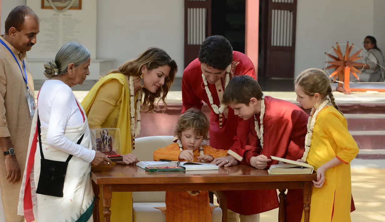 Perdana Menteri Kanada Justin Trudeau bersama keluarga melihat putra mereka Hadrien saat menandatangani sebuah buku pengunjung di Gandhi Ashram di Ahmedabad, India (19/2). (AFP Photo/Sam Panthaky)