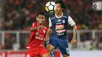 Gelandang Persija, Ramdani Lestaluhu (kiri) berebut bola dengan pemain Arema FC, Hanif Sjahbandi saat laga lanjutan Go-Jek Liga 1 Indonesia 2018 bersama Bukalapak di Stadion GBK Jakarta, Sabtu (31/3). Persija unggul 3-1. (Liputan6.com/Helmi Fithriansyah)