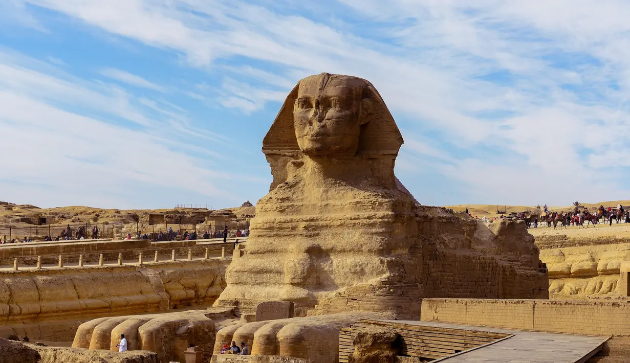 Sejumlah wisatawan melihat bangunan Sphinx di kompleks Piramida Giza di pinggiran Ibukota Kairo, Mesir (6/12). Di kompleks ini berdiri tiga Piramid besar ditambah satu buah Sphinx. (AFP Photo/Mohamed El-Shahed)