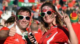 Suporter Wales pantas bergembira karena untuk pertama kalinya Wales lolos dari fase grup Piala Eropa. (AFP/Remy Gabalda)