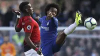 Gelandang Chelsea, Willian, berebut bola dengan gelandang Manchester United, Paul Pogba, pada laga Premier League di Stadion Stamford Bridge, Sabtu (20/10/2018). Kedua tim bermain imbang 2-2. (AP/Matt Dunham)