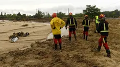Petugas pemadam kebakaran melihat mobil-mobil yang terdampar di tepi sungai di kota Aldea del Fresno, di wilayah Madrid, Spanyol, Senin (4/9/2023). (Oscar DEL POZO CAÑAS / AFP)