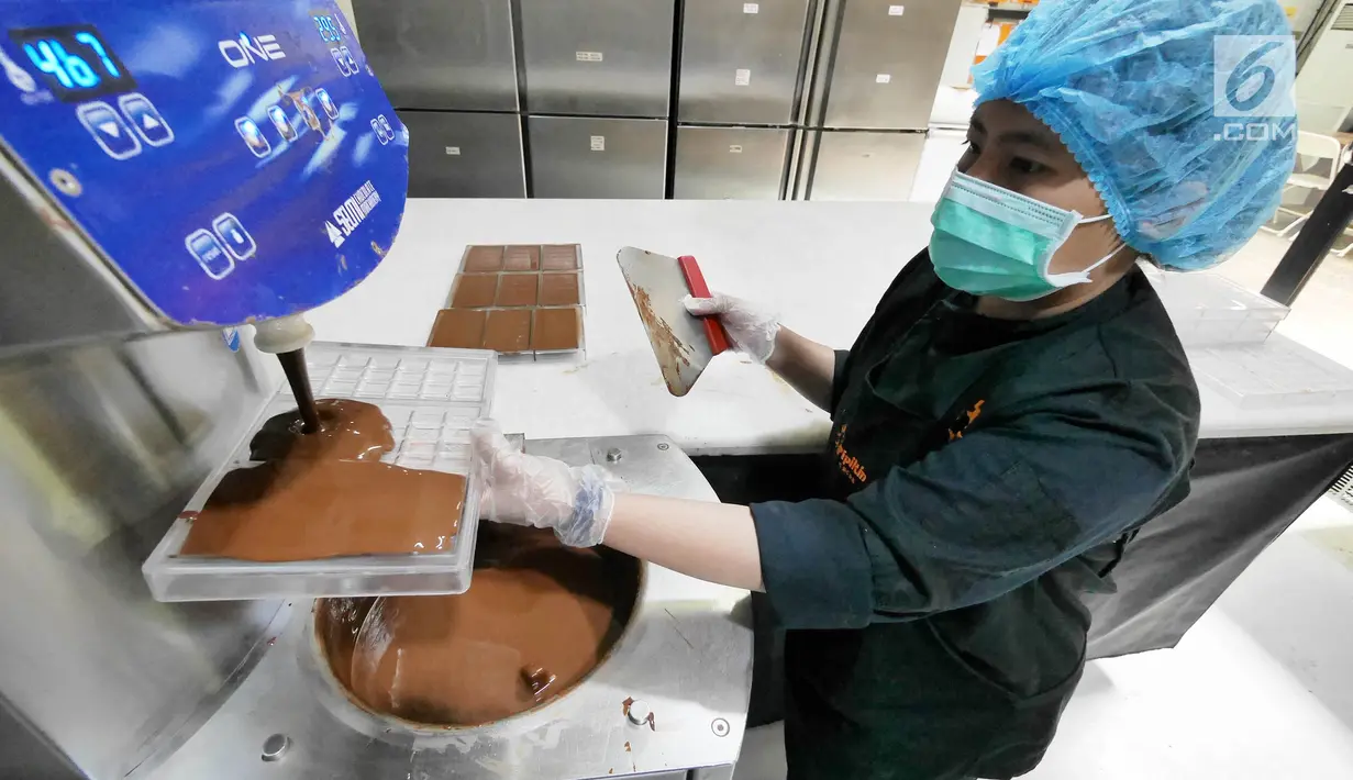 Pekerja memasukkan cokelat cair ke dalam alat cetak di toko Pipiltin Cocoa kawasan Barito, Jakarta, Kamis (13/9). Pipiltin Cocoa cukup banyak diburu oleh para atlet Asian Games 2018. (Liputan6.com/Herman Zakharia)