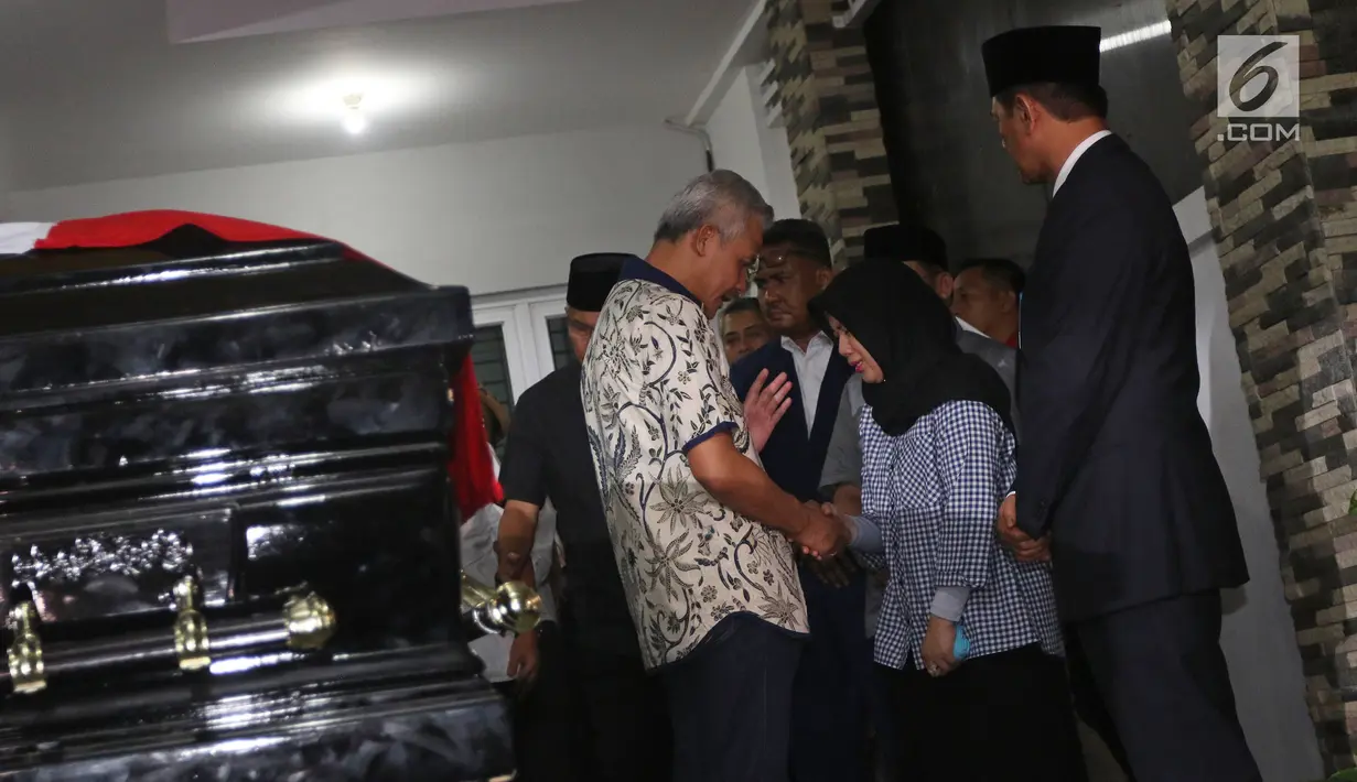 Gubernur Jawa Tengah Ganjar Pranowo menyapa Retno Utami, istri Kepala Pusat Data Informasi dan Humas Badan Nasional Penanggulangan Bencana (BNPB) Sutopo Purwo Nugroho saat melayat ke rumah duka di Raffles Hils, Cimanggis, Depok, Jawa Barat, Minggu (7/7/2019). (Liputan6.com/Herman Zakharia)
