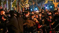 Polisi dan orang-orang digambarkan dalam bentrokan di Shanghai pada 27 November 2022, di mana protes terhadap kebijakan nol-COVID China terjadi pada malam sebelumnya menyusul kebakaran mematikan di Urumqi, ibu kota wilayah Xinjiang. (Foto: AFP/Hector Retamal)