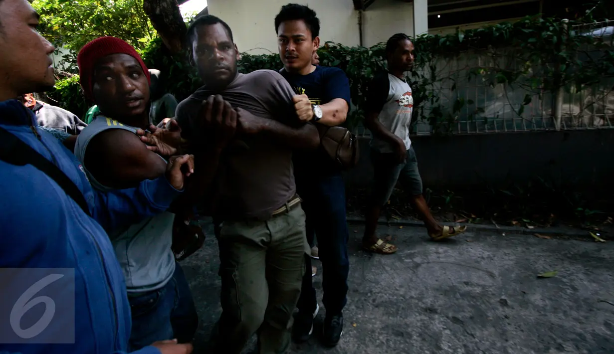 Petugas polisi berpakaian preman membekuk warga Papua yang melakukan demonstrasi di depan Asrama Mahasiswa Papua di Yogyakarta, Jumat (15/7). Mereka menggelar aksi menuntut kemerdekaan Papua. (Liputan6.com/Boy Harjanto)