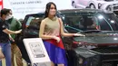 Seorang Sales Promotion Girl (SPG) berdiri di samping kendaraan pada Gaikindo Indonesia International Auto Show (GIIAS) 2021 di ICE BSD, Tangerang, Senin (15/11/2021). Kehadiran model menghiasi pameran otomotif GIIAS 2021 yang berlangsung hingga 21 November mendatang. (Liputan6.com/Angga Yuniar)