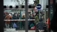 Warga Ukraina menunggu di perbatasan Slovakia-Ukraina di Velke Slemence, Slovakia (25/2/2022). Warga Ukraina mulai melarikan diri dari konflik di negara mereka sehari setelah Rusia melancarkan serangan militer. (AFP/Peter Lazar)