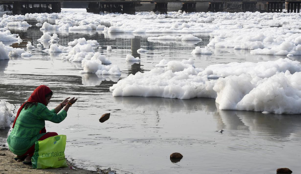 Seorang wanita berdoa di Sungai Yamuna yang tercemar di New Delhi, Sabtu (8/7). Pada 1909, air sungai ini tergolong sebagai "biru jernih" bila dibandingkan dengan Sungai Gangga yang berwarna kuning kecoklatan. (DOMINIQUE FAGET / AFP)