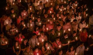 Umat Kristiani menyalakan lilin selama misa Hari Natal di Gereja Bethany, Surabaya, Jawa Timur pada Kamis 25 Desember 2025. Puluhan ribu umat Kristiani memadati Gereja Bethany Nginden Surabaya untuk mengikuti ibadah Natal pada Kamis (25/12/2025) malam. (JUNI KRISWANTO/AFP)