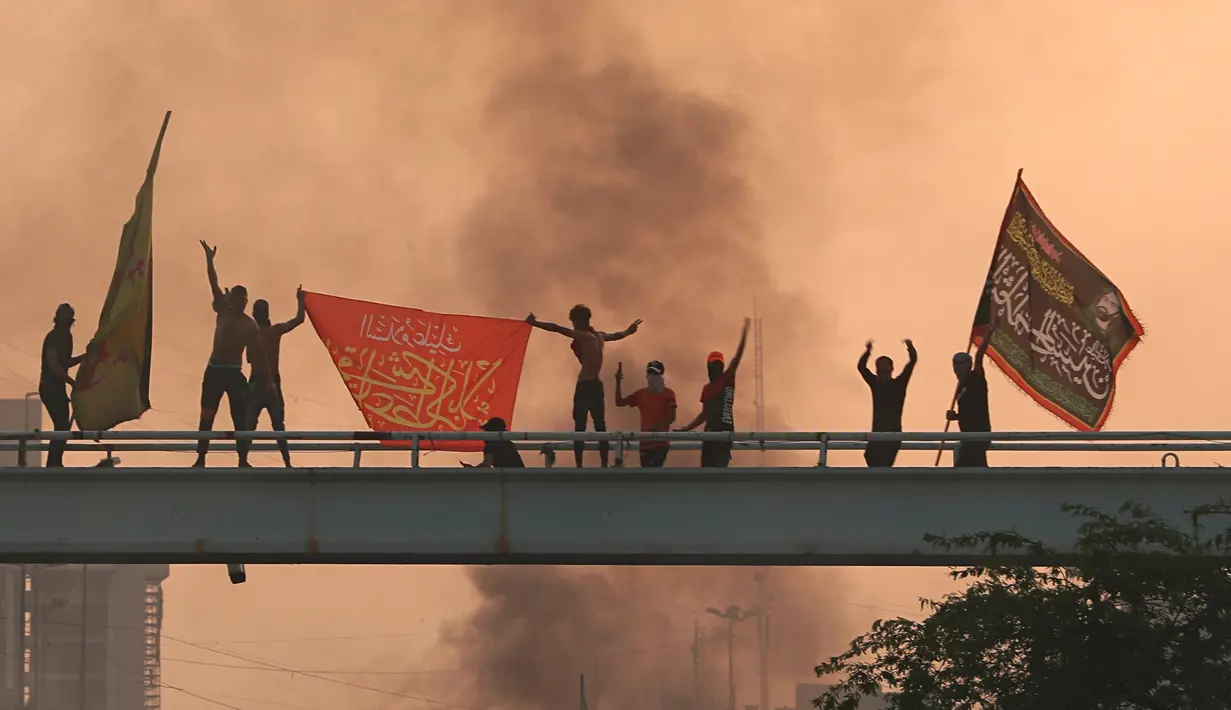 Pengunjuk rasa antipemerintah meneriakkan slogan-slogan selama protes di Baghdad, Irak, Rabu (2/10/2019). Para pejabat Irak mengatakan beberapa pengunjuk rasa tewas dan sejumlah lainnya terluka di tengah baku tembak dan bentrokan di Baghdad. (AP Photo/Hadi Mizban)