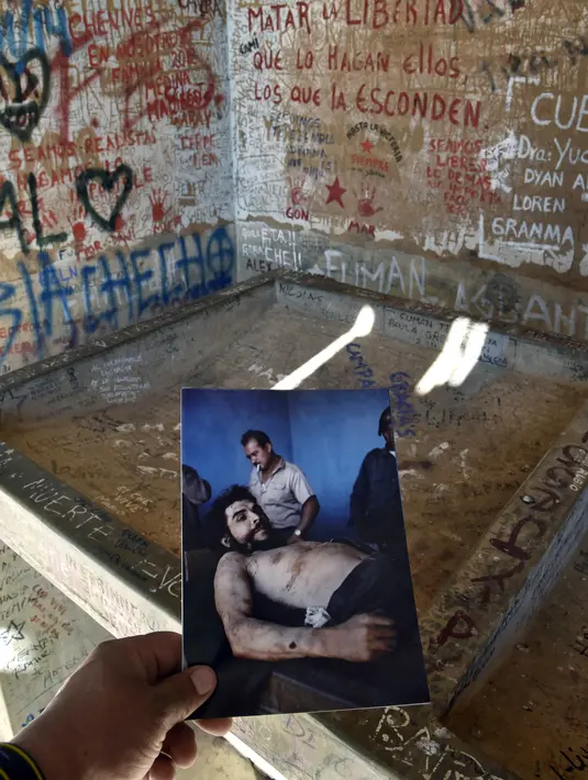 Seorang wartawan menunjukkan salinan foto dari gambar Che Guevara yang diambil oleh wartawan AFP, Marc Hutten pada tanggal 10 Oktober 1967 di Bolivia (30/9). (AFP Photo/Aizar Raldes)