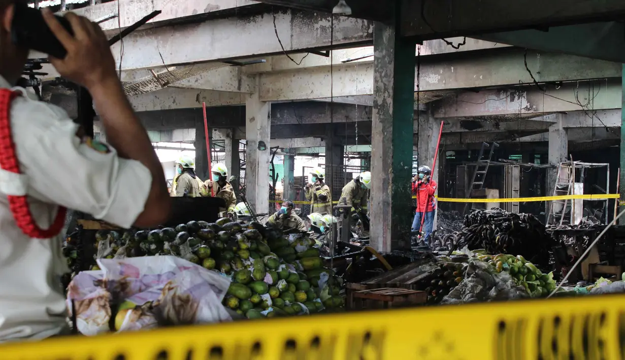 Saat ini, kebakaran yang menghanguskan kios buah di Pasar Induk Kramat Jati sudah berhasil dipadamkan. Sejumlah personel Damkar terus melakukan upaya pendinginan di lokasi. Tampak dalam foto, beberapa pedagang berupaya menyelamatkan sisa dagangannya setelah api yang membakar Pasar Induk Kramat Jati Jakarta berhasil dipadamkan pada Senin (15/12/2025). (merdeka.com/magang/Rendi Saputra)