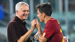 Pelatih AS Roma, Jose Mourinho (kiri) bergurau dengan pemain AS Roma, Paulo Dybala saat laga lanjutan Liga Italia melawan Monza di Olympic Stadium, Roma, Italia, 30 Agustus 2022. (AFP/Alberto Pizzoli)