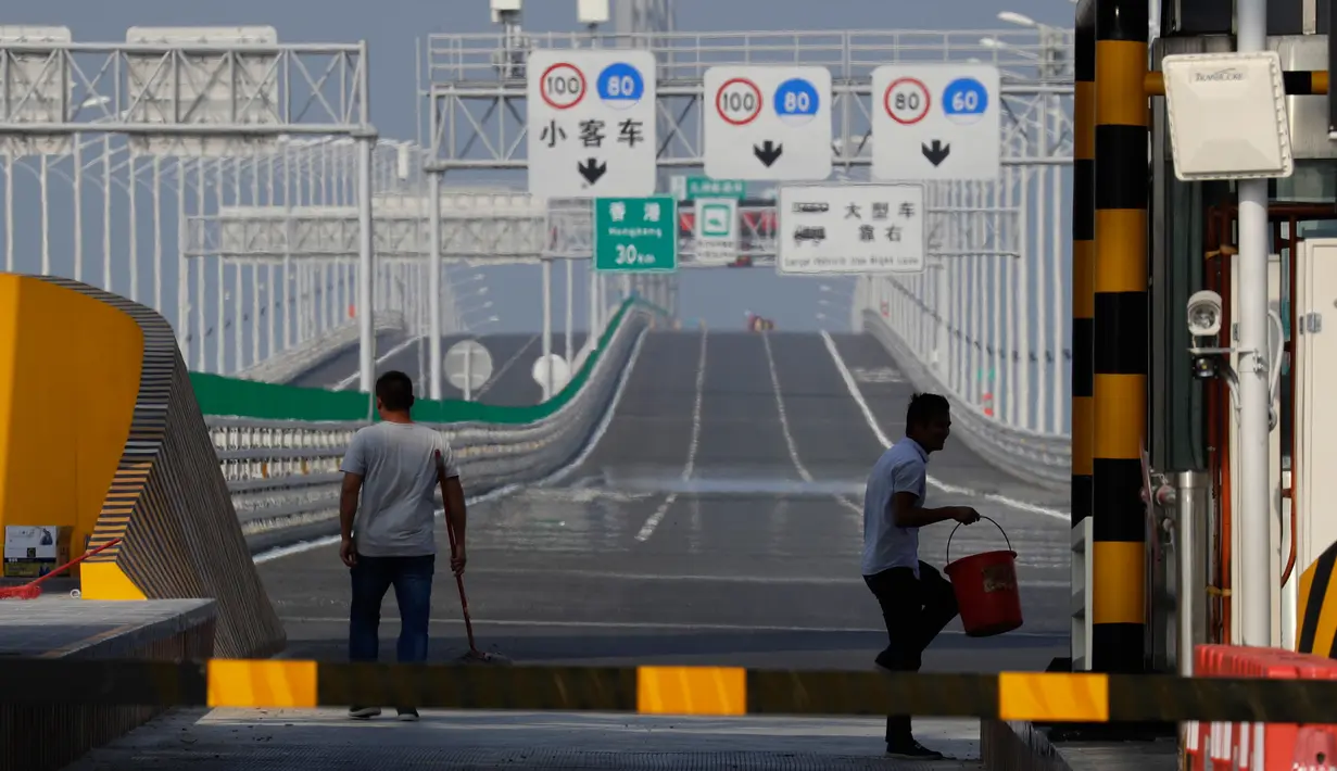 Pekerja membersihkan permukaan Jembatan Hong Kong-Zhuhai-Macau di kota Zhuhai, China selatan, Rabu (28/3). Pekerja menggunakan 420 ribu ton baja untuk membangun jembatan ini, yang cukup untuk membangun 60 Menara Eiffel. (AP Photo/Kin Cheung)
