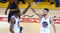 Pemain Golden State Warriors Kevin Durant (35) dan Stephen Curry (30) melakukan selebrasi saat bertanding melawan Cleveland Cavaliers di gim pertama Final NBA 2017 di Oracle Arena di Oakland, California (1/6). (Thearon W. Henderson/Getty Images/AFP)