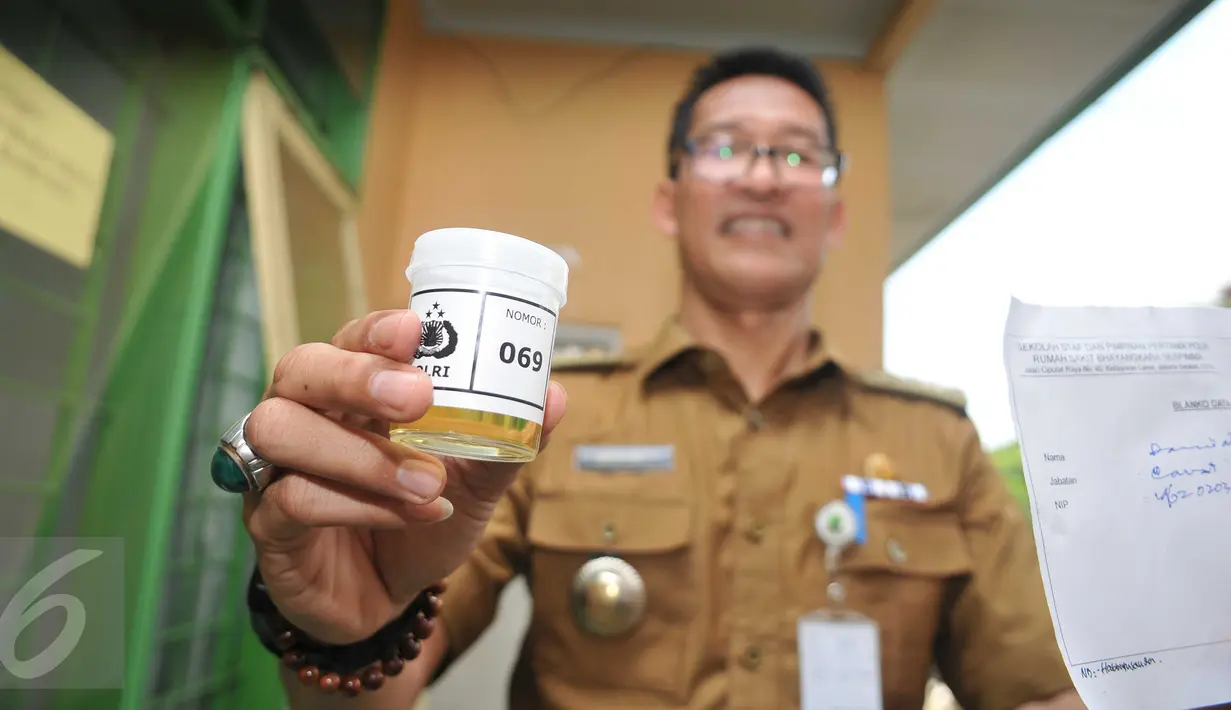 Seorang pegawai menunjukkan sampel urine saat pemeriksaan di Kecamatan Larangan, Ciledug, Tangerang, Senin (25/4).  Sekitar 130 PNS dan non PNS se Kecamatan Larangan dites urine untuk mengantisipasi penyalahgunaan narkoba. (Liputan6.com/Gempur M Surya)