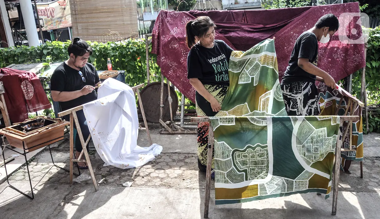 Pengajar menjemur batik hasil pelatihan di Rumah Batik Palbatu, Jakarta, Minggu (2/10/2022). Dalam rangka memeriahkan Hari Batik Nasional, Rumah Batik Palbatu menggelar pelatihan membatik kepada masyarakat umum sebagai upaya meningkatkan minat terutama bagi generasi milenial dalam melestarikan seni kriya tersebut. (merdeka.com/Iqbal S. Nugroho)