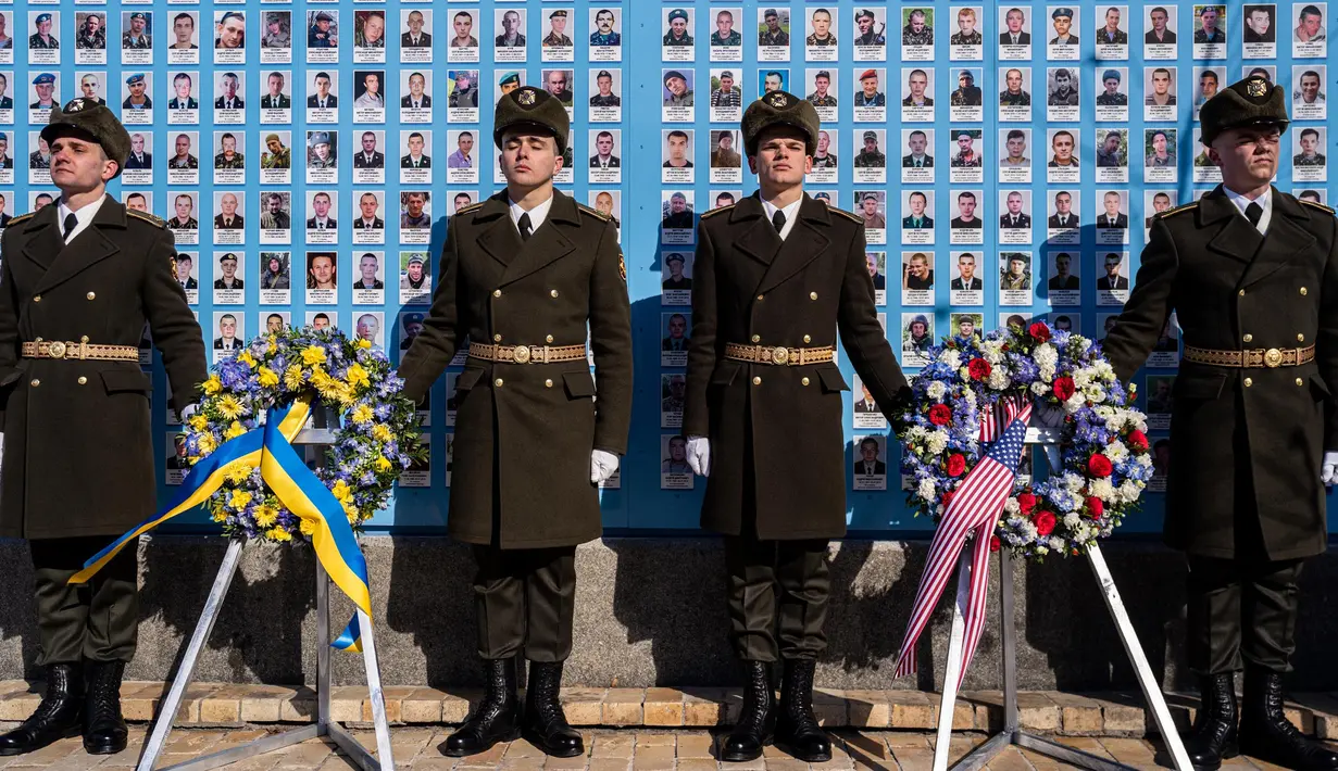 Pasukan kehormatan Ukraina berdiri di depan Tugu Peringatan bagi mereka yang Gugur untuk Ukraina di Kyiv pada tanggal 20 Februari 2023. Presiden AS Joe Biden menjanjikan peningkatan pengiriman senjata untuk Ukraina selama kunjungan mendadak ke Kyiv pada 20 Februari 2023, di mana ia juga menjanjikan komitmen Washington dalam membela integritas teritorial Ukraina. (Dimitar DILKOFF/AFP)