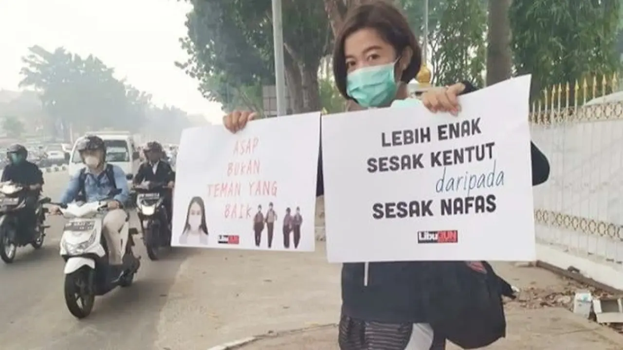 Anggota salah satu komunitas di Pekanbaru membawa selebaran sebagai protes dampak kabut asap kebakaran lahan di Riau.