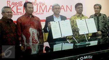 Ketua KPU Pusat Juri Ardiantoro (kedua kanan) dan Ketua Komisi informasi Publik John Fresly (ketiga kiri) menunjukkan nota kesepakatan di Gedung KPU, Jakarta, Selasa (29/11).  (Liputan6.com/Helmi Afandi)