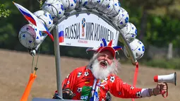 Tingkah lucu perancang sepeda asal Jerman, Dieter Senft atau Didi the Devil saat mengendarai sepeda unik buatannya di Briesen, Jerman Timur, Senin (7/5). Aksi itu dia lakukan untuk mempromosikan Piala Dunia 2018. (Patrick Pleu/dpa/AFP)