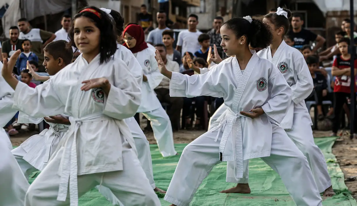 Sejumlah anak perempuan menunjukkan keterampilannya selama upacara promosi Karate di sebuah pusat olahraga di kamp Rafah untuk pengungsi Palestina di Jalur Gaza selatan (20/9/2019). (AFP Photo/Said Khatib)