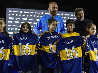 Gelandang baru Boca Juniors, Daniele De Rossi bersama Presiden Boca Juniors Daniel Angelici foto bersama dengan anak-anak selama pengenalan dirinya di Buenos Aires, Argentina (29/7/2019). De Rossi yang 36 tahun mengakhiri 18 tahun karirnya di Roma akhir musim lalu. (AP Photo/Tomas F. Cuesta)