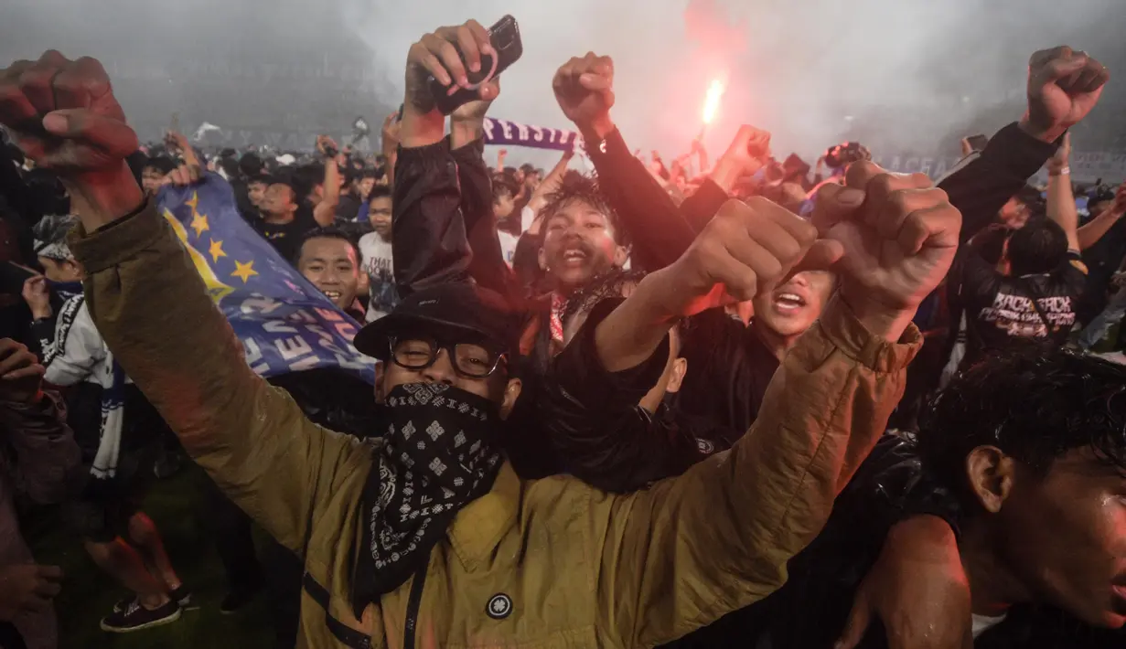 Namun sangat disayangkan, momen bersejarah perayaan juara BRI Liga 1 Indonesia 2024-2025 dinidai dengan ulah sejumlah supporter yang masuk ke lapangan. (Timur Matahari/AFP)