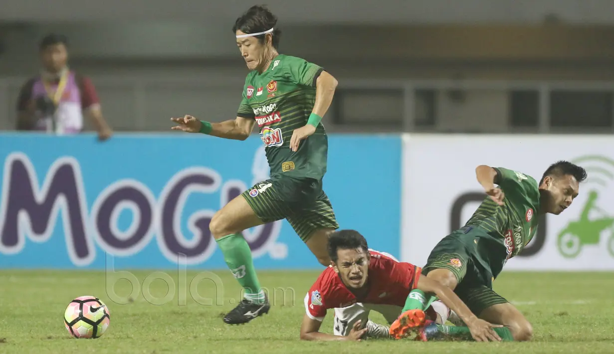 Pemain Persija Jakarta, Ambrizal Umanailo (tengah) terjatuh saat berebut bola dengan pemain PS TNI pada laga Liga 1 2017 di Stadion Pakansari, Bogor, (8/6/2017). (Bola.com/Nicklas Hanoatubun)