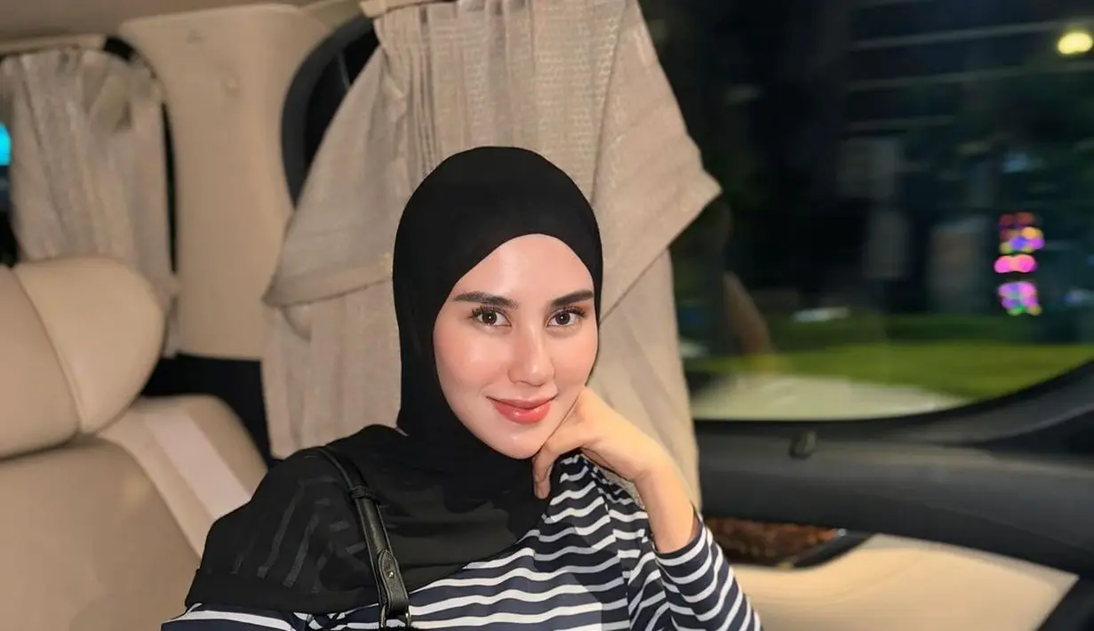 Penampilan manis Syahnaz Sadiqah pakai outfit hitam-putih. Ia memadukan atasan kaus bercorak garis hitam-putih rok pleats panjang dan hijab hitam polos. [Foto: Instagram/syahnazs]