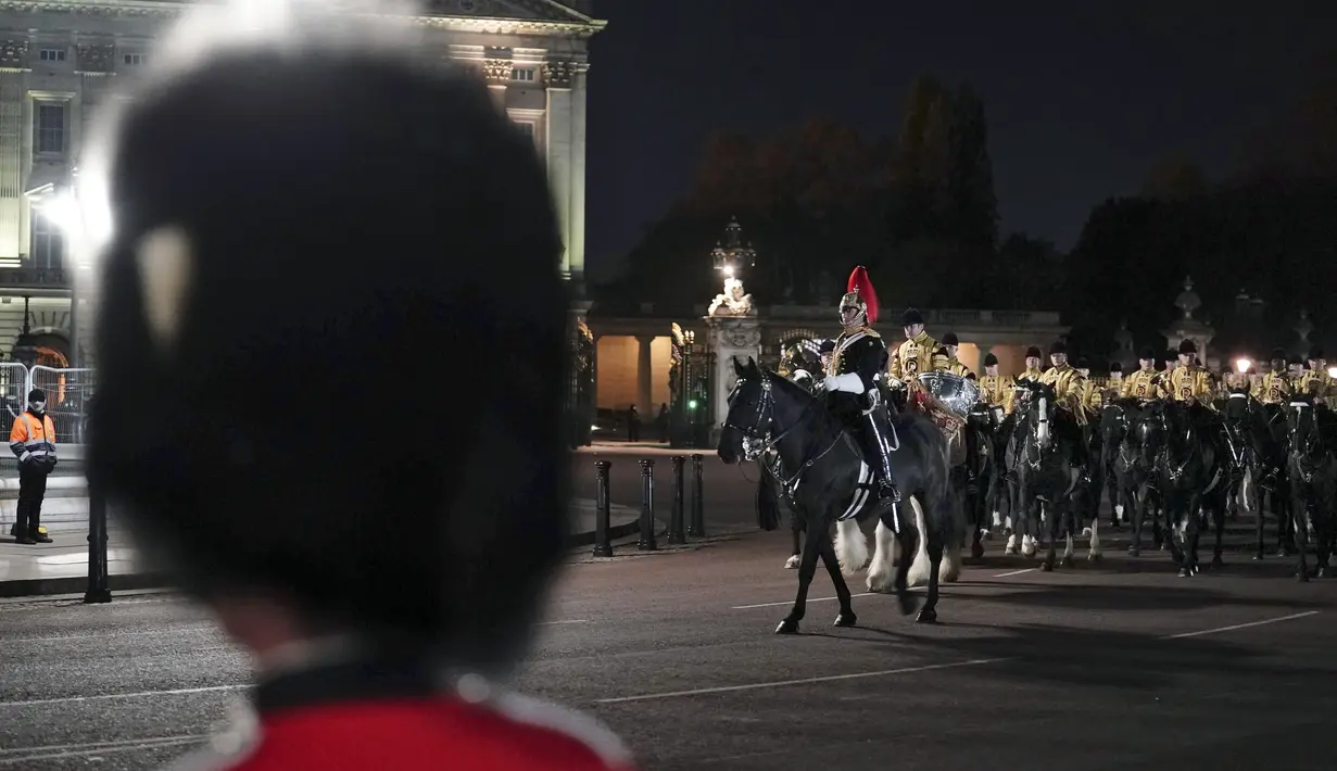 Anggota militer berbaris di dekat Istana Buckingham di pusat kota London, Selasa, 2 Mei 2023 saat latihan untuk penobatan Raja Charles III yang akan berlangsung di Westminster Abbey pada 6 Mei. (Jordan Pettitt/PA via AP)