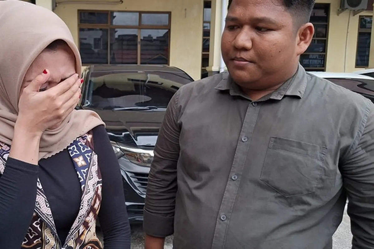 Korban kekerasan dalam rumah tangga yang dilakukan oknum polisi di Polresta Pekanbaru mengusap matanya mengingat penganiayaan yang pernah dialaminya.