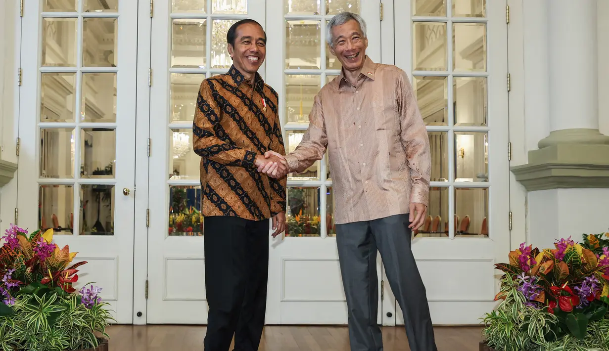 Keduanya berbincang-bincang santai dari halaman Istana Kepresidenan Singapura, sebelum masuk ke ruangan. (EDGAR SU/POOL/AFP)