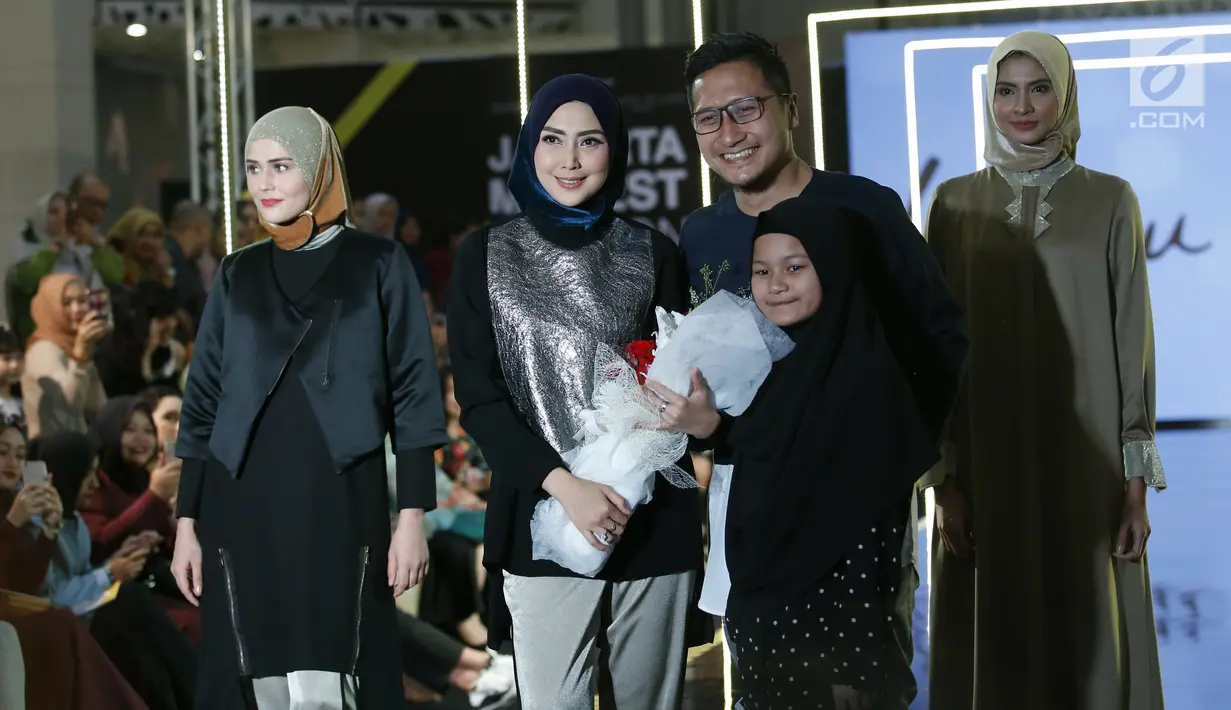 Fenita Arie bersama suami Arie Untung dan anaknya foto bersama di atas catwalk dalam ajang Jakarta Modest  Fashion Week, di Gandaria City, Jakarta, Jumat, (27/7). (Kapanlagi.com/Agus Apriyanto)