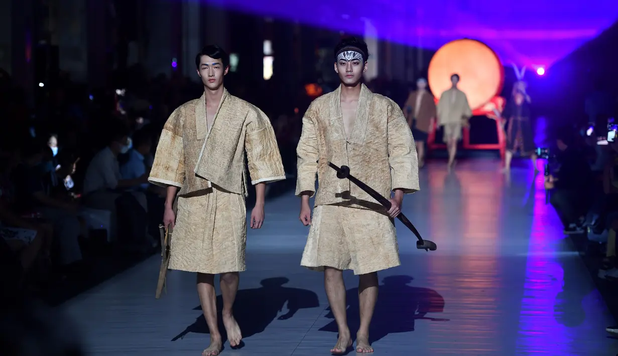 Dua model memeragakan kreasi busana yang terbuat dari brokat Li, pakaian tradisional yang dibuat oleh kelompok etnis Li, dalam sebuah peragaan busana di Haikou, Provinsi Hainan, China selatan, pada 19 November 2020. (Xinhua/Guo Cheng)